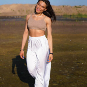 Happy young woman walking through the field in the morning