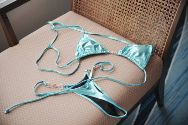 Close up of woman bra throwing at wooden chair.
